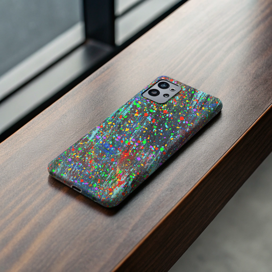 A Colorful Abstract Drip Paint Durable Phone Case covers a smartphone, splattered with vibrant colors, as it sits on a wooden windowsill with natural light streaming through the window behind it.