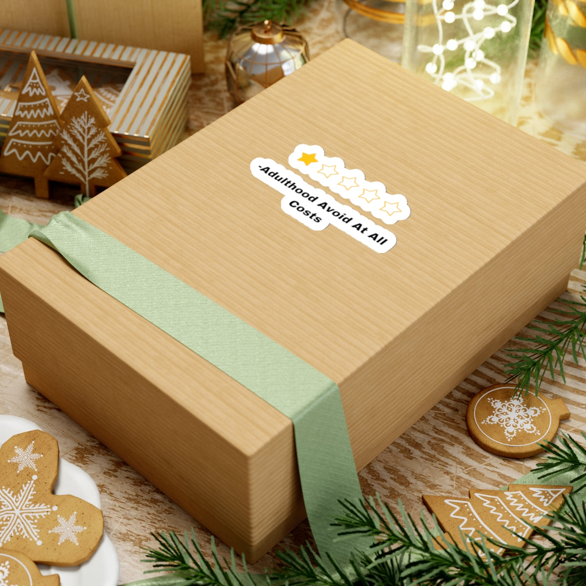 Adulthood review sticker with star rating on brown gift box wrapped with green ribbon surrounded by holiday decorations