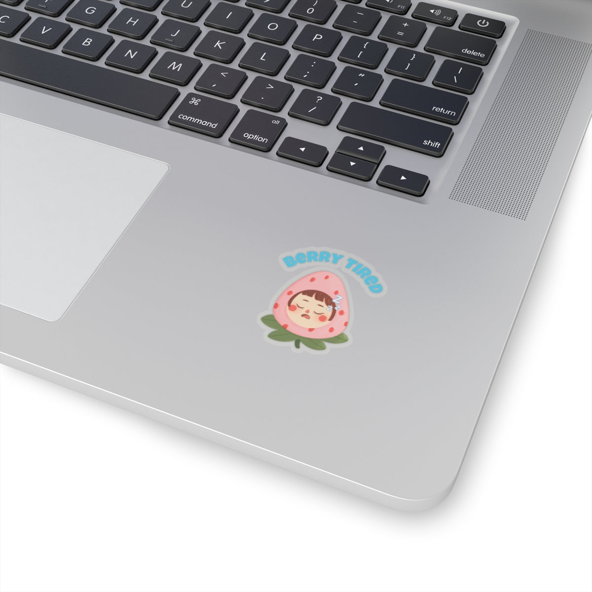 Berry tired vinyl sticker with a cute sleepy character on a silver laptop keyboard area