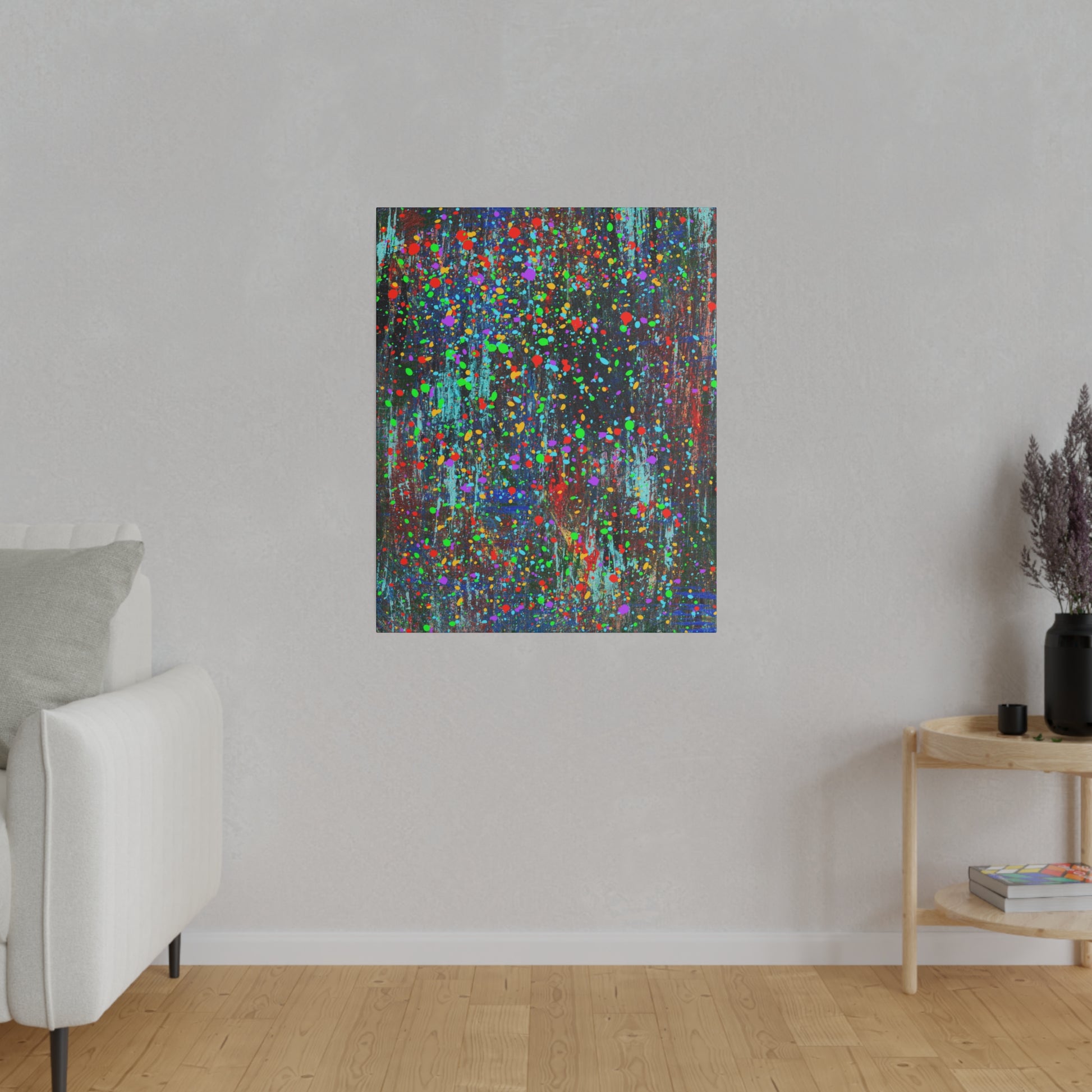 Color drip explosion art canvas print hanging on gray wall above wooden floor near white sofa and side table
