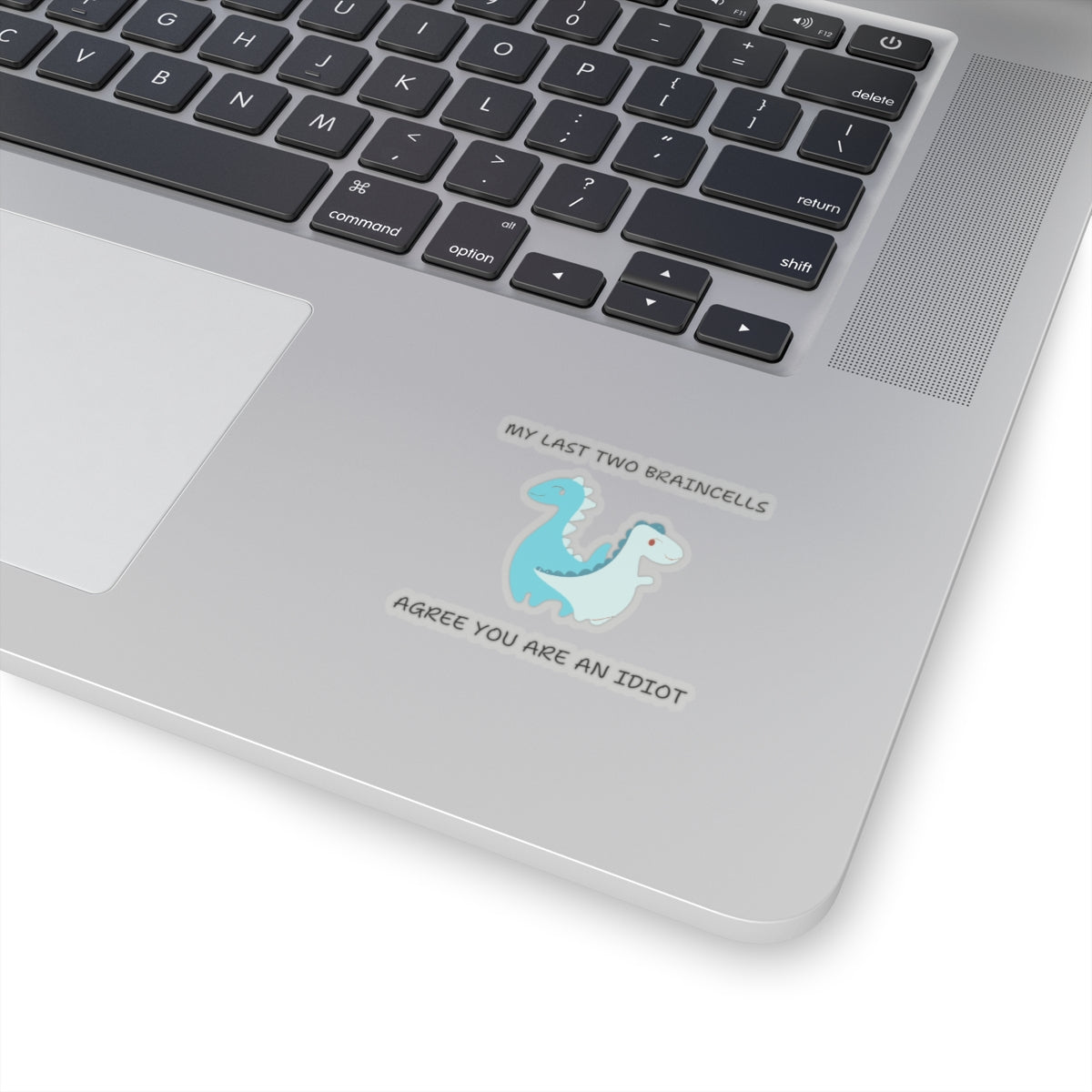 Cute dinosaur meme stickers with humorous text applied on silver laptop palm rest
