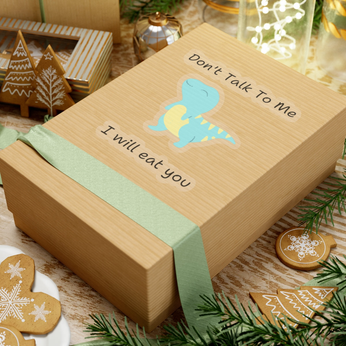 Do not talk to me funny cute dino sticker on a brown gift box with green ribbon and holiday decorations