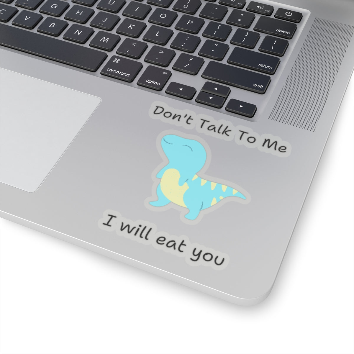 do not talk to me funny cute dino sticker on silver laptop near keyboard with blue dinosaur design