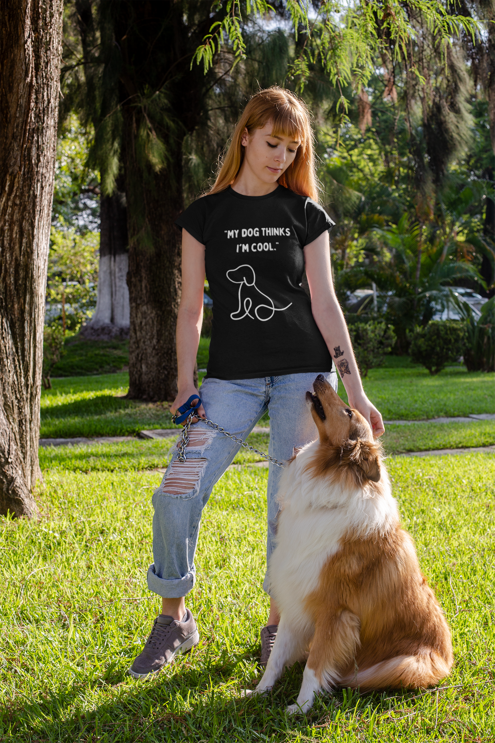 Woman wearing a My Dog Thinks I Am Cool Dog Unisex Shirt with her dog in a sunny park setting