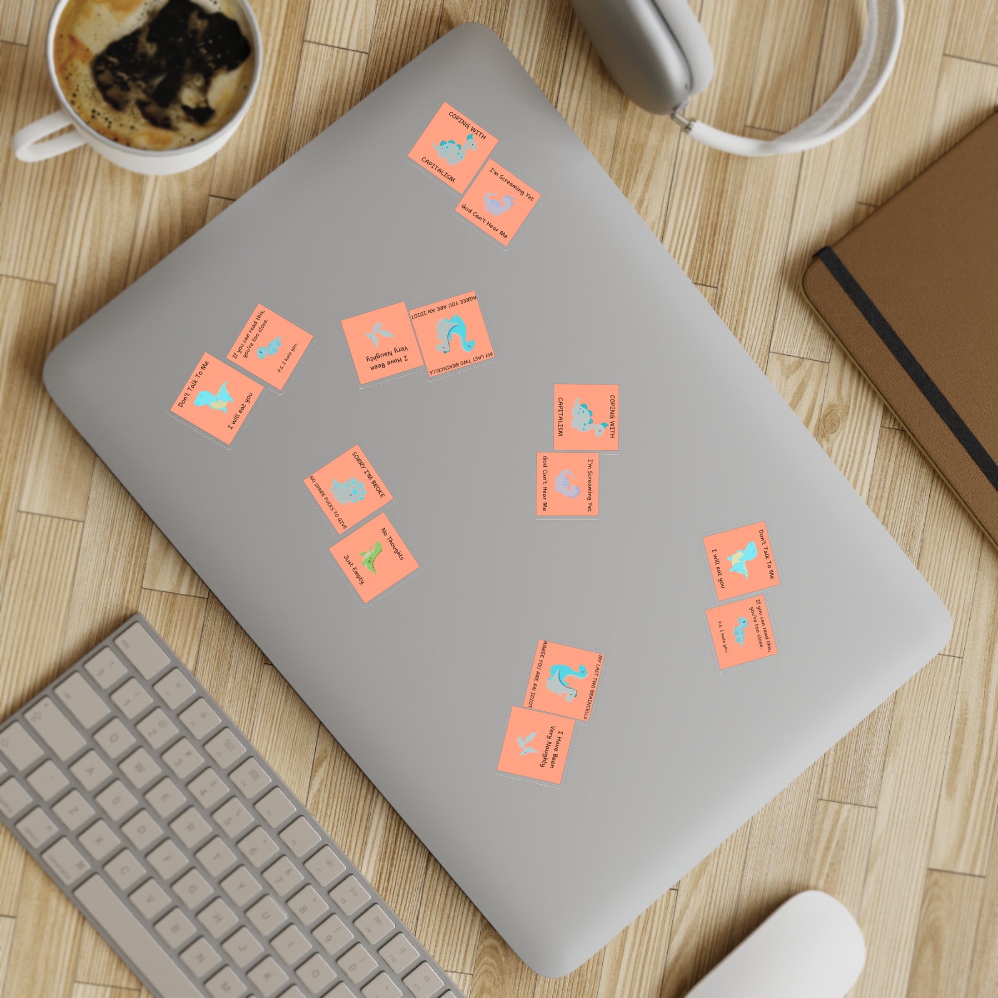 Funny edgy sarcastic cute dino sticker bundle on a laptop with a keyboard and coffee mug