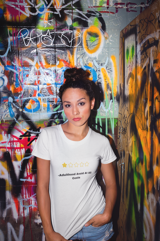 Woman in white fitted t shirt against graffiti wall wearing funny adulthood review t shirt with one star and slogan