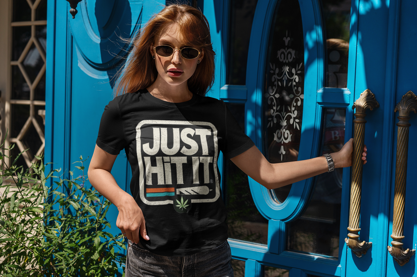 Woman wearing Printify black funny weed just do it meme  t-shirt with JUST HIT IT cannabis graphic outdoors