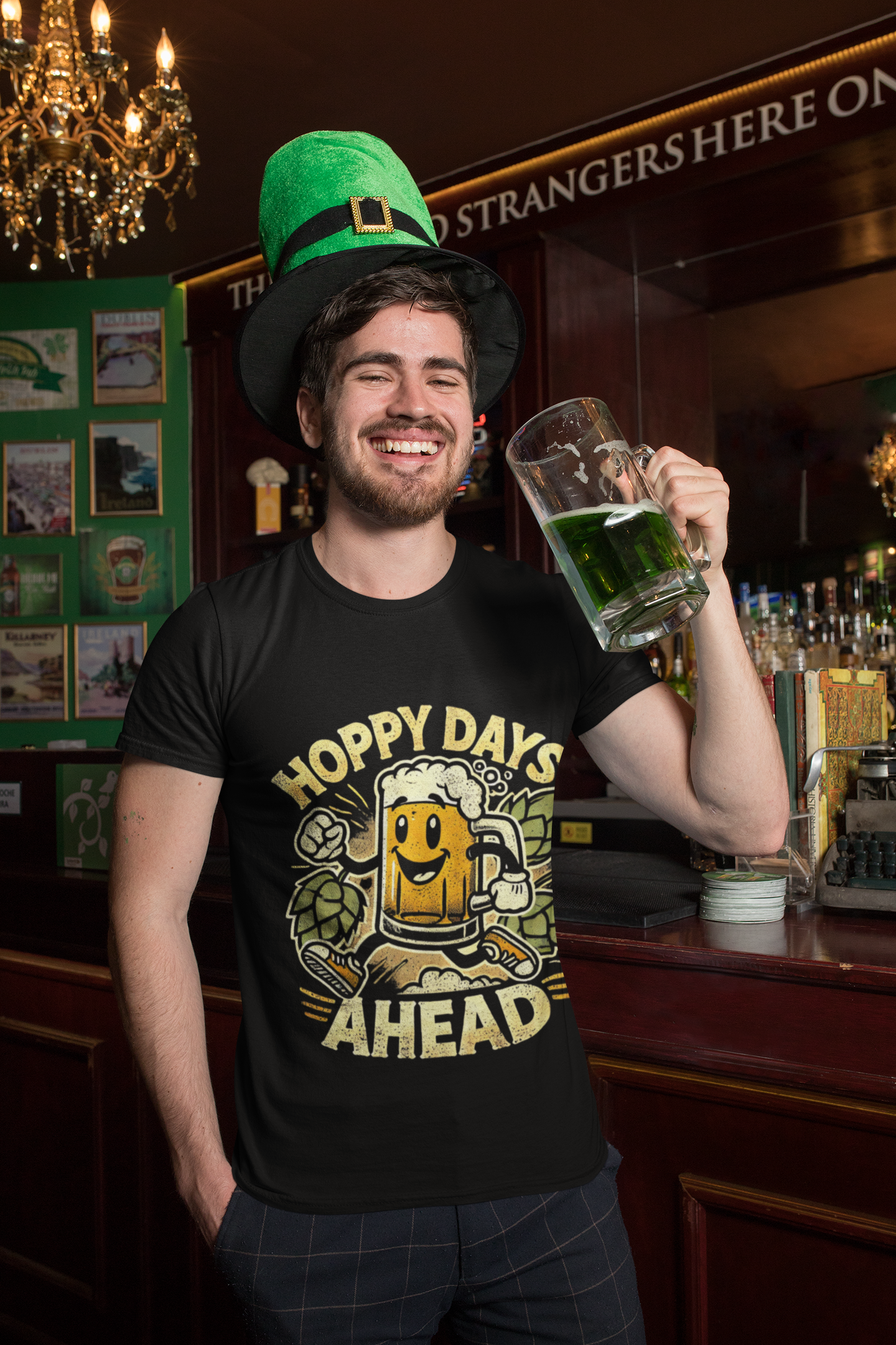 Man in pub wearing Printify black funny beer lover hoppy days ahead  t-shirt holding green beer mug and leprechaun hat