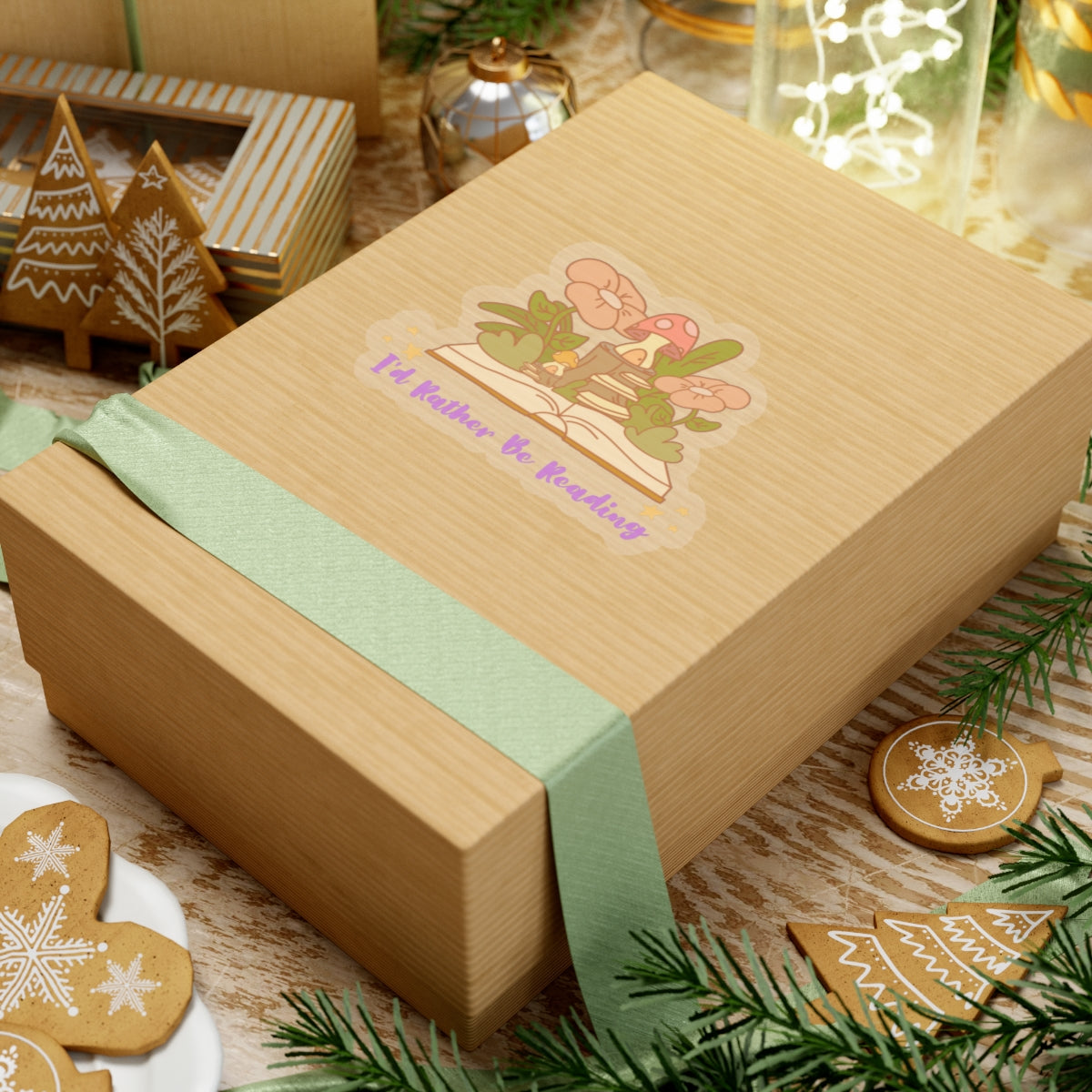 Gift box with green ribbon featuring an I'd rather be reading cute book lover sticker on a festive wooden table