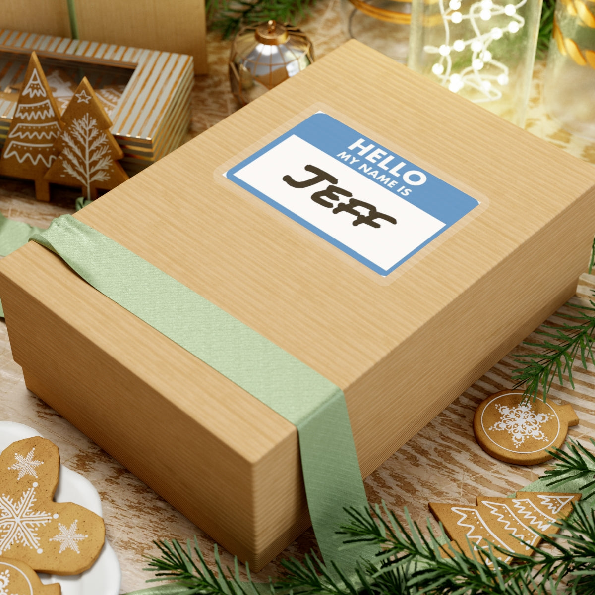 Hello my name is Jeff sticker on a wrapped gift box with holiday decorations and cookies