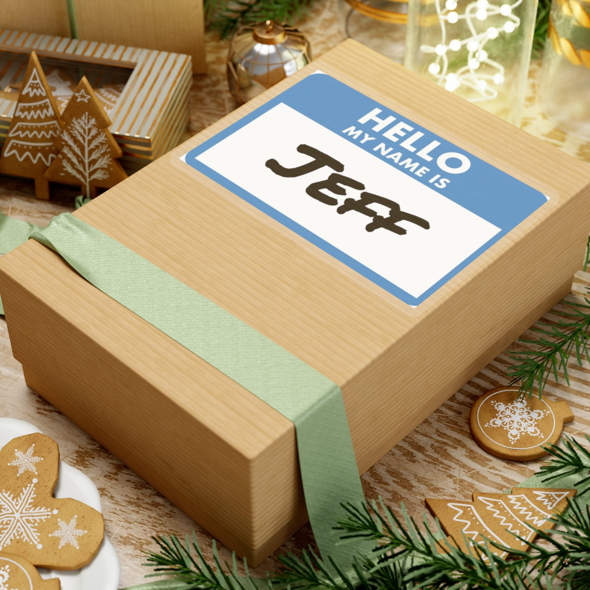 Holiday gift box with my name is Jeff sticker on top surrounded by festive gingerbread cookies and decorations