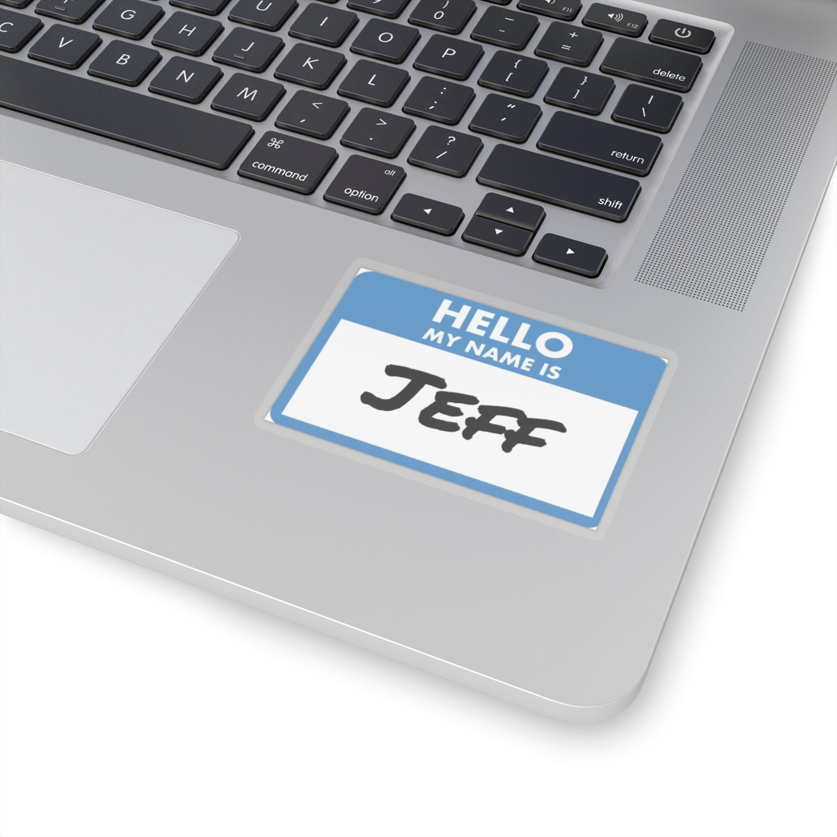 Hello my name is Jeff sticker placed on silver laptop keyboard area with black keys