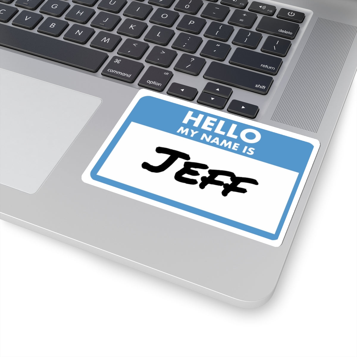 Printify my name is Jeff sticker placed on a silver laptop near the keyboard