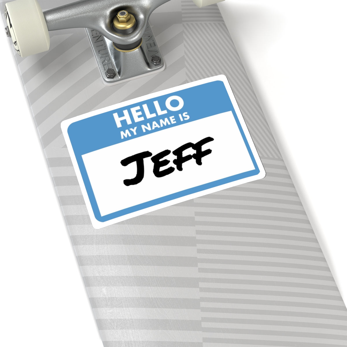 Printify my name is Jeff sticker placed on a gray skateboard deck near the wheel