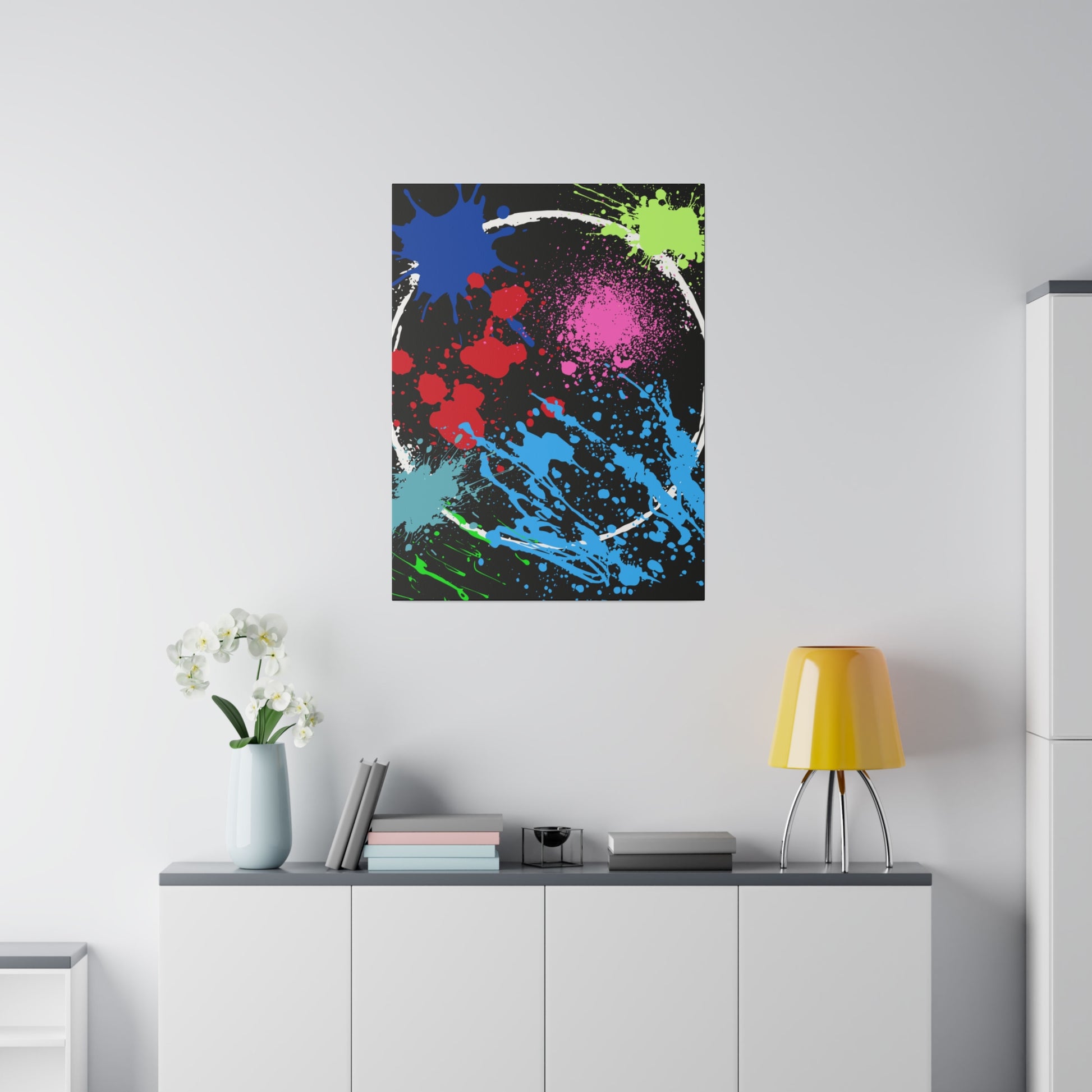 Neon eclipse abstract canvas wall art with colorful splatters hanging above white cabinet