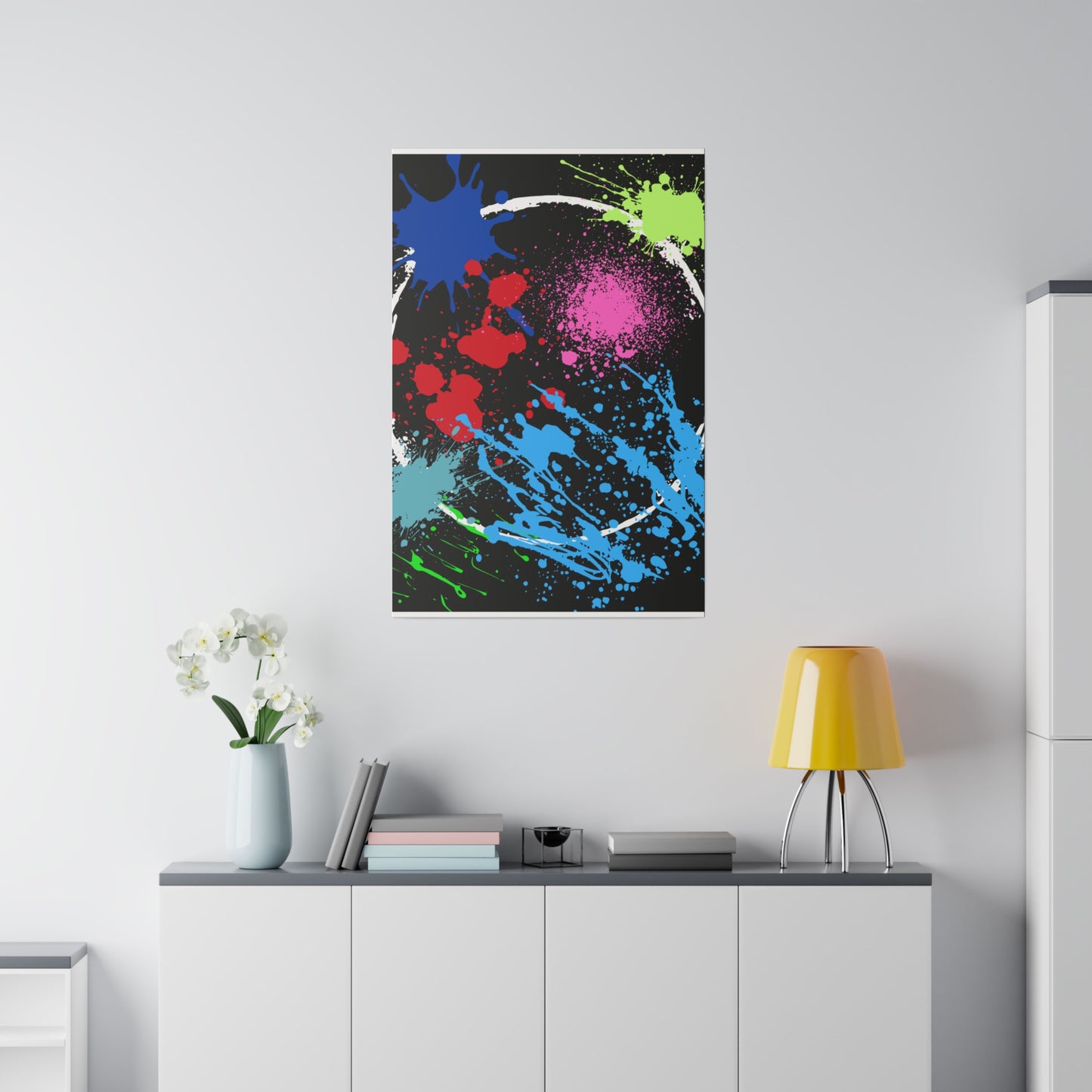 Neon eclipse abstract canvas wall art with colorful paint splatters hanging above white cabinet