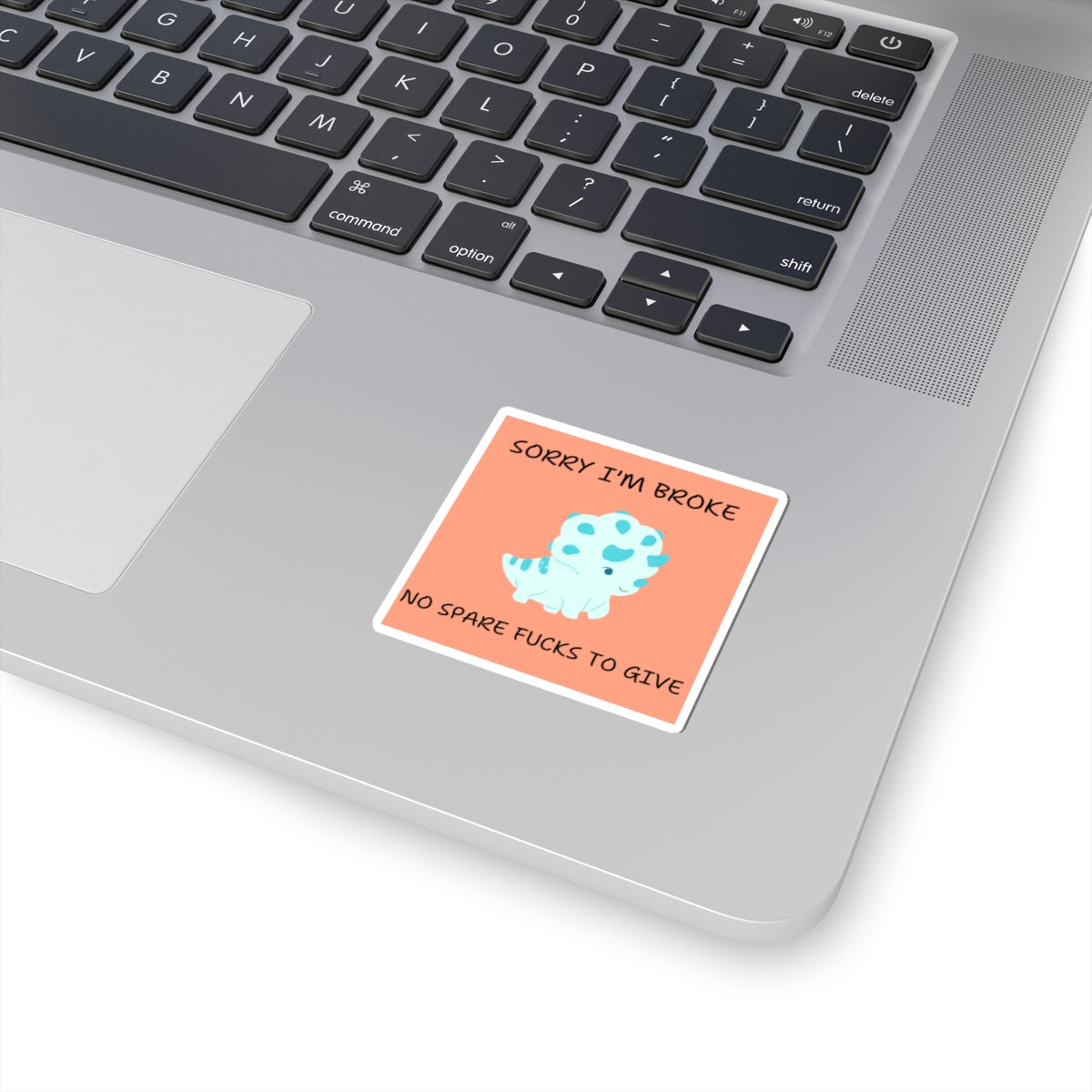 No fucks to give funny dino sticker with blue dinosaur on peach background placed on laptop