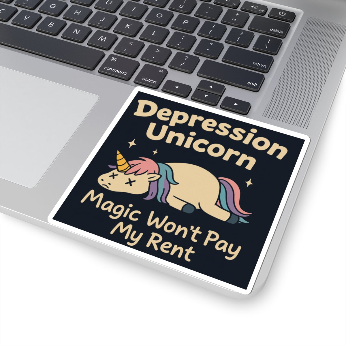 Funny cute unicorn art sticker on laptop showing a sad Depression Unicorn and text Magic Wont Pay My Rent
