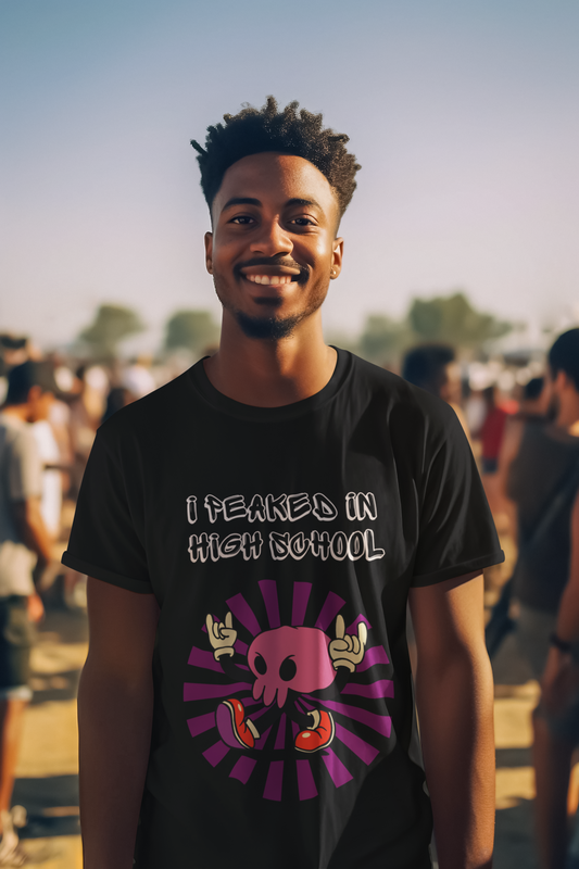 I Peaked in High School funny t-shirt on smiling man wearing black graphic tee at outdoor festival Printify