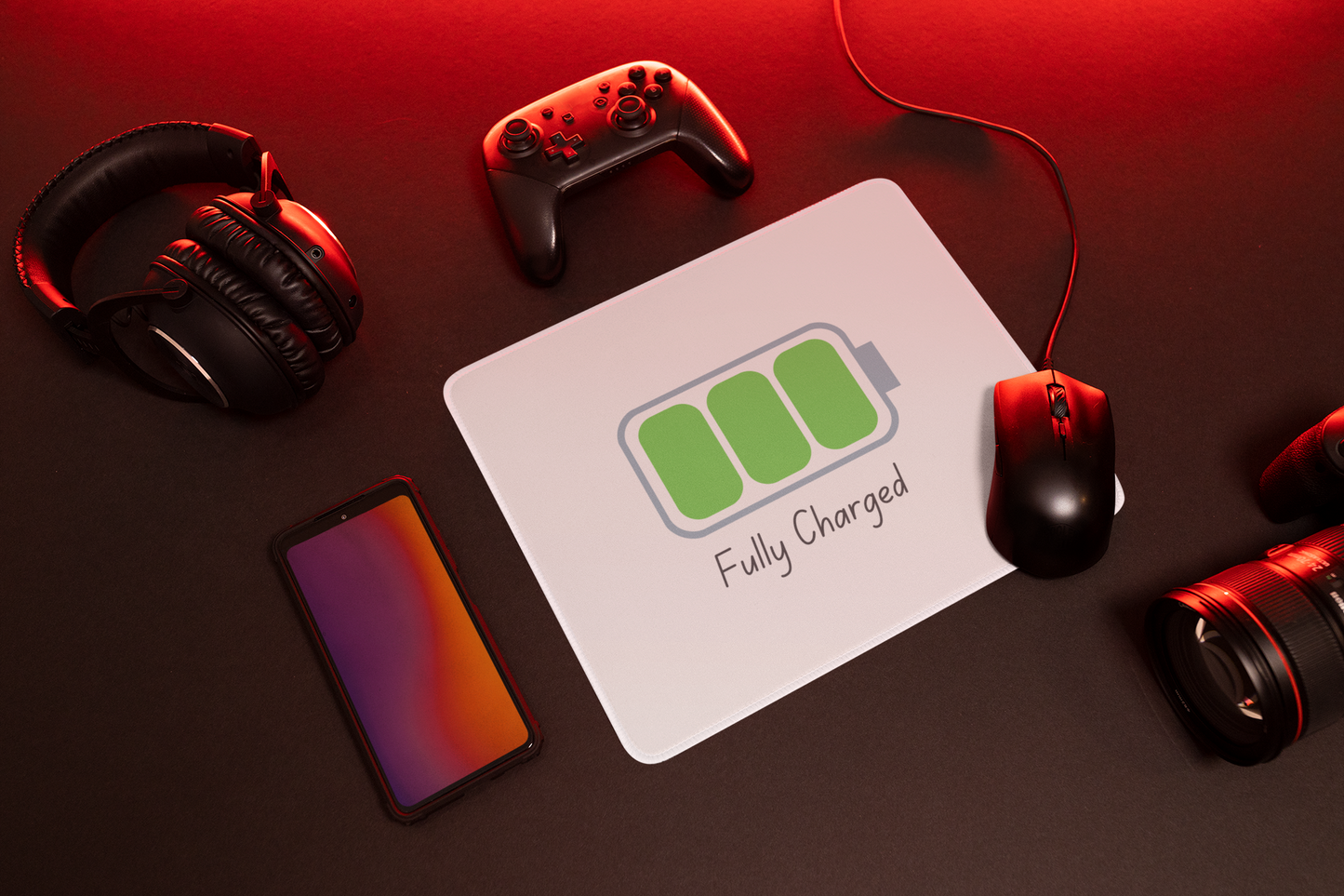 Printify fully charged gaming mouse pad on dark desk with wired mouse controller headphones phone and camera lens