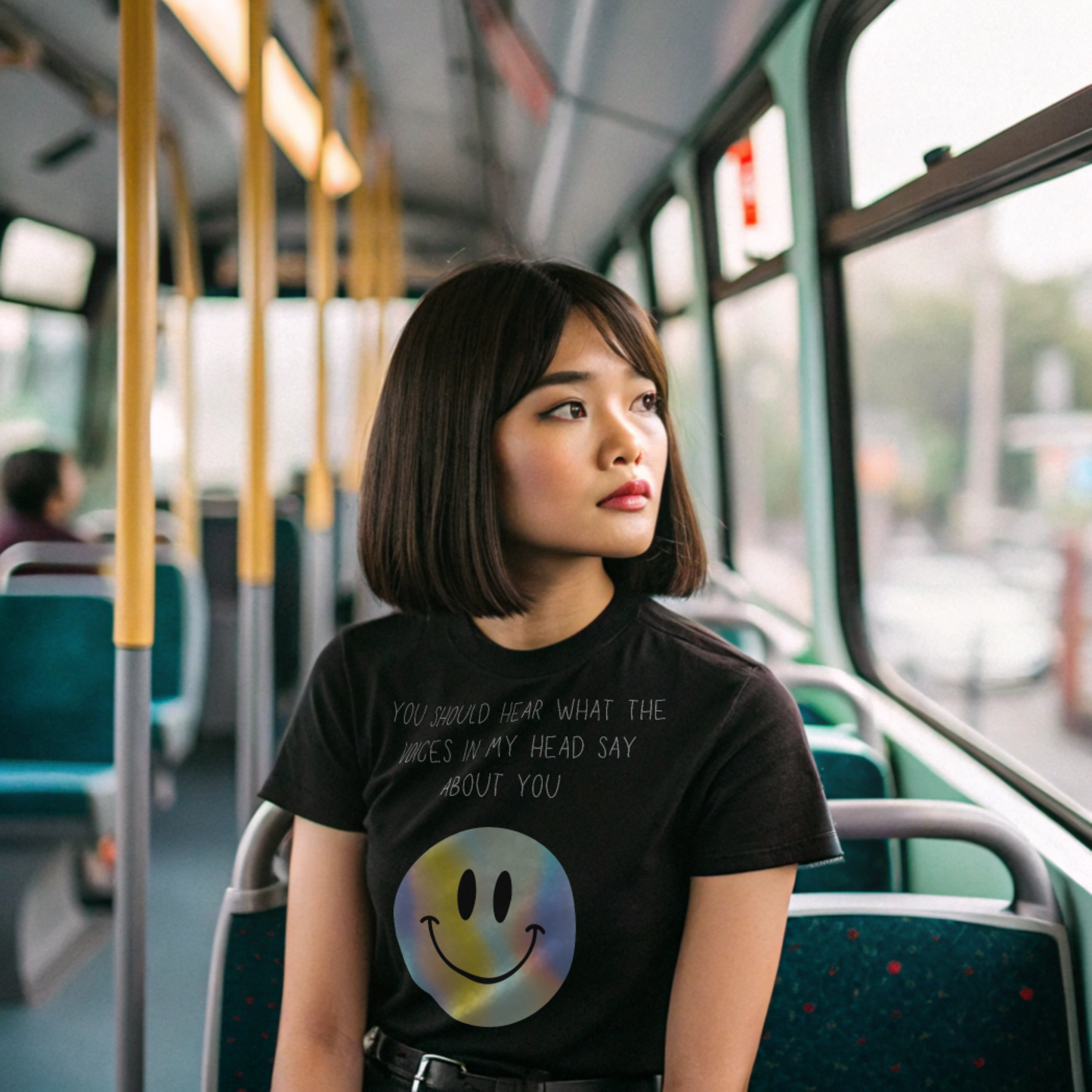 Young woman wearing a voices in my head funny smiley face unisex shirt sitting on a bus