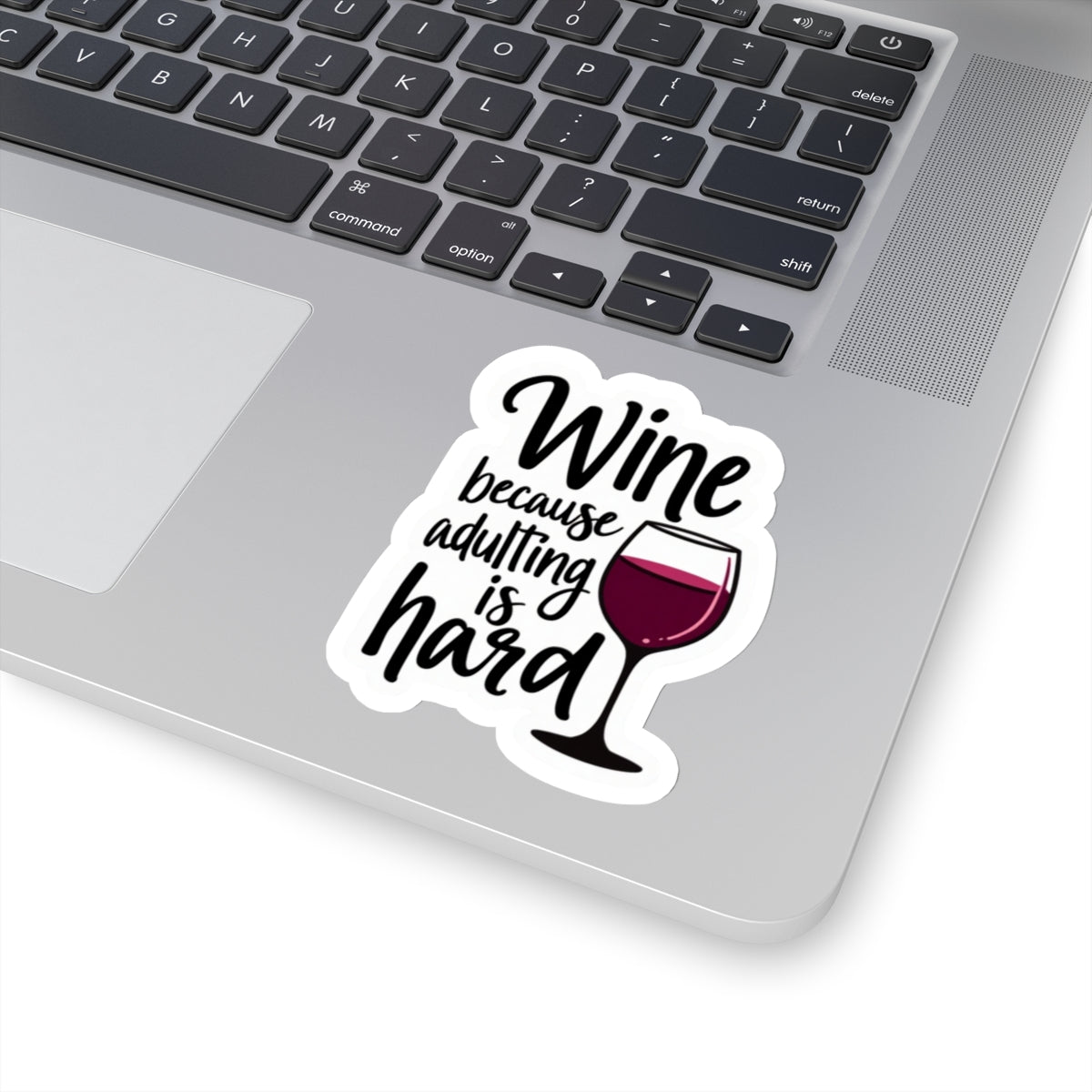 Wine because adulting is hard funny sticker on silver laptop keyboard showing wine glass and text design